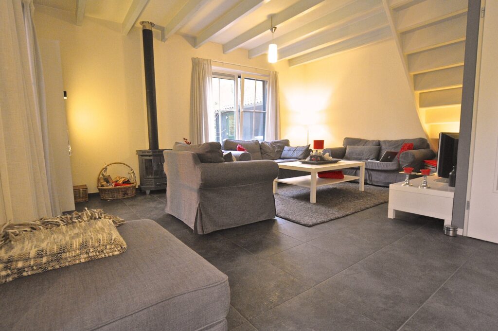 Een gezellige woonkamer met zachte bank en stoel en een warme houtkachel